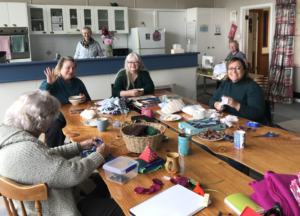 People doing craft around a table.
